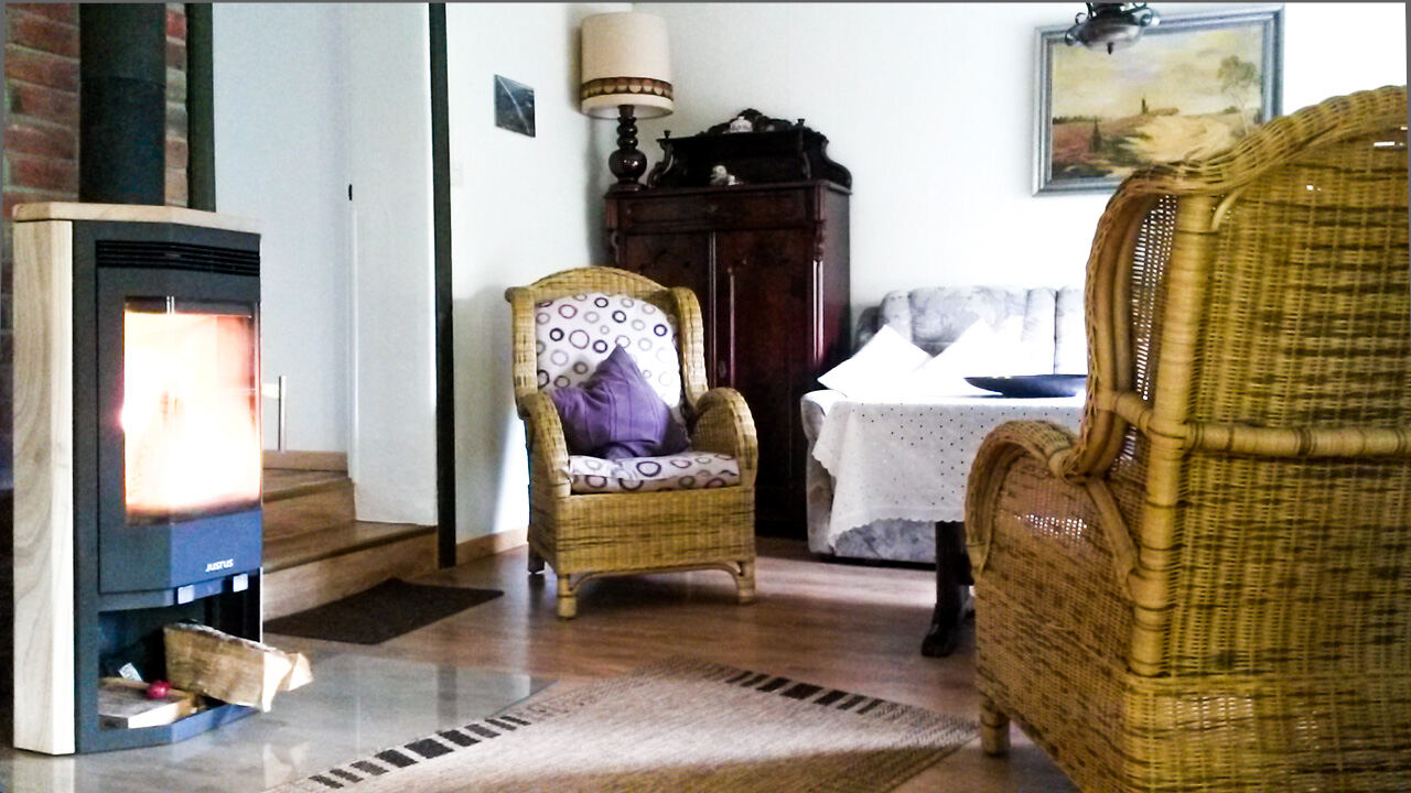 Wohnzimmer des Ferienhauses mit Kaminofen und Essecke